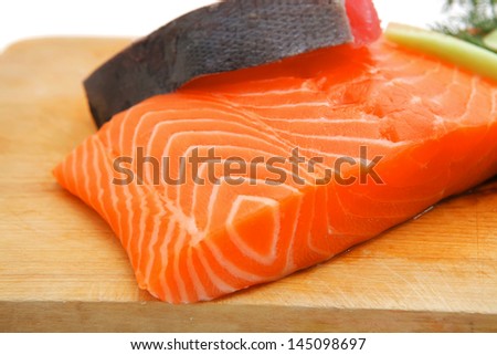 uncooked fresh salmon and red tuna fish pieces served over wooden board isolated on white background