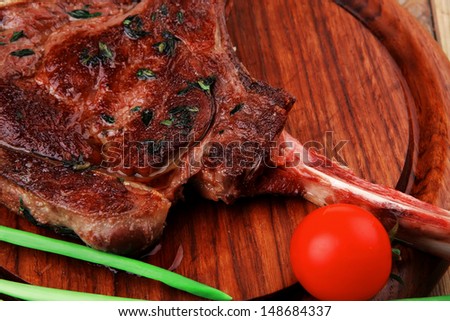 meat savory : roasted beef ribs served with green chives and cherry tomato over wood