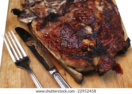 meat steak on wooden plate with fork and knife