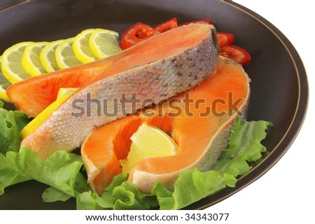 two salmon steak on dark dish over white