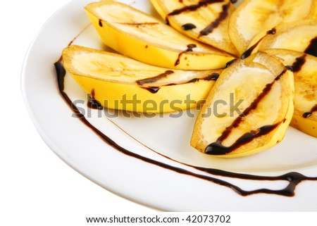 ripe sliced banana with chocolate sauce on white