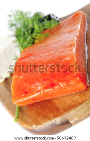 single pink salmon bit on a big wooden dish with white cheese