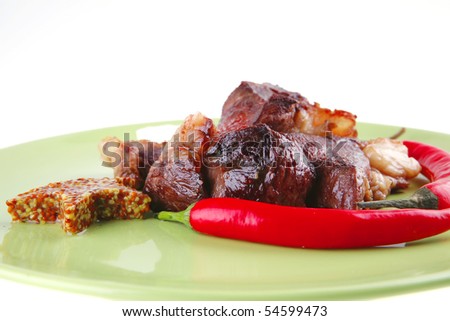 meat main course served on green plate over white