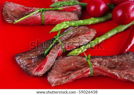 red meat slices and vegetables on red plate