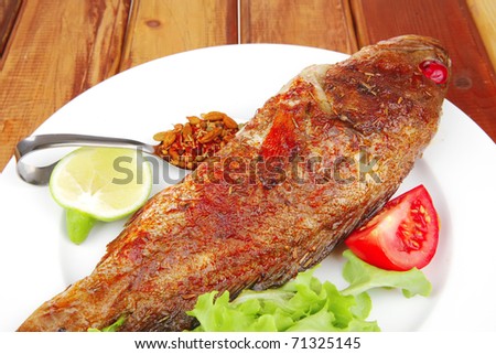 savory on wood: fried fish served with tomatoes lemon and spices