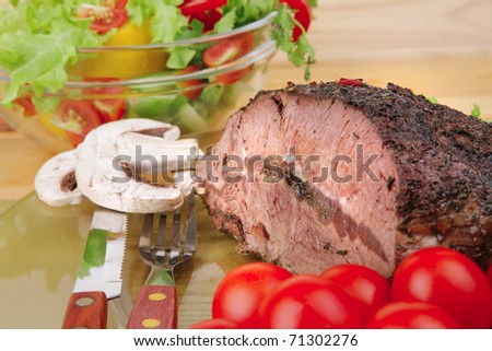 hot beef on transparent plate with salad bowl . shallow dof