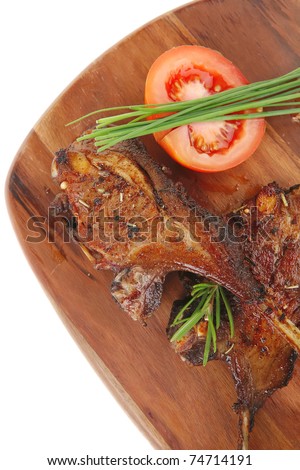 meat over wood: grilled ribs on plate with tomatoes and spices isolated on white background