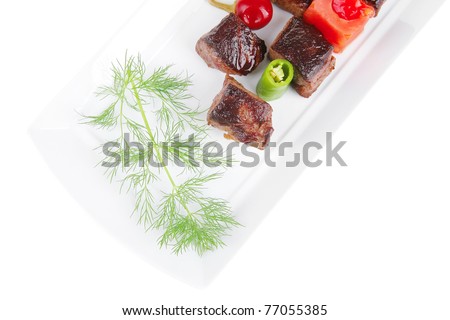 european food: roast beef meat goulash over white plate isolated on white background with tomatoes and dill