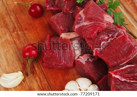 raw fresh beef meat fillet on a wooden plate with dill , hot green red peppers isolated over white background