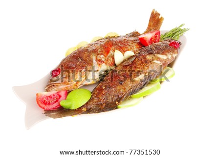 savory : roast golden fish served on fish plate with lemon tomatoes and rosemary
