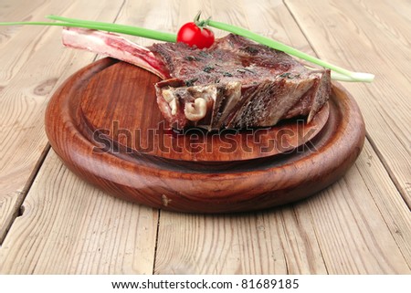 meat savory : grilled beef ribs served with green chives and cherry tomato over wood