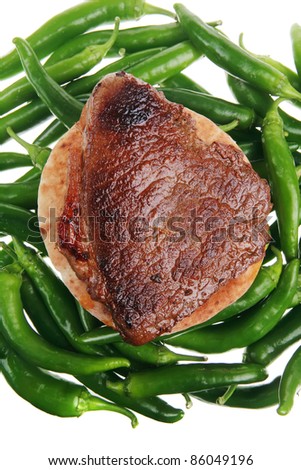 meaty food : grilled red meat steak over arabic pita on a green hot chili peppers on a white back background