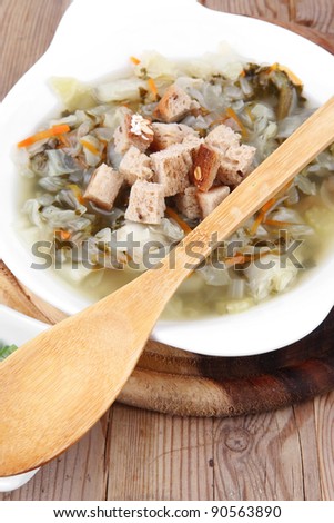 diet food : hot vegetable soup with bread  crackers in white bowl on wood stand over table