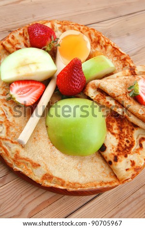 baked and fruits : pancake with honey strawberries and apple on wooden table