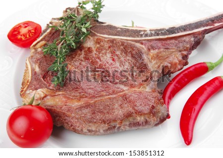 meat food : grilled beef spare rib on white dish with thyme pepper and tomato isolated over white background