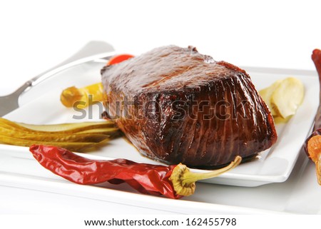 meat chunk served on white with knife and fork
