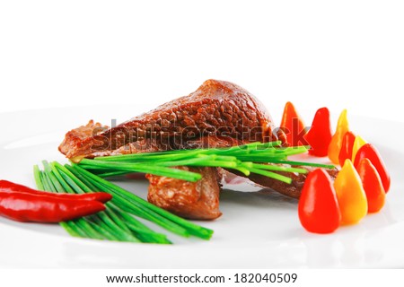 hot fresh grilled red beef meat fillet with vegetables  green chives and peppers on china plate isolated over white background