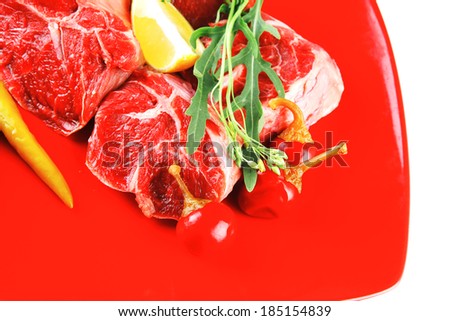 fresh raw beef red meat fillet medallion chunks on red plate isolated over white background
