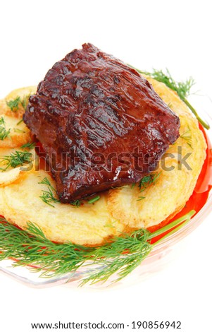 fresh roast beef meat chunk in transparent bowl over baked potatoes and tomatoes served with fill isolated over white background