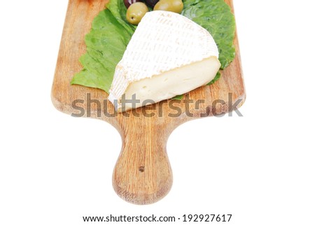 camembert cheese on wooden platter with olives and tomato isolated over white background