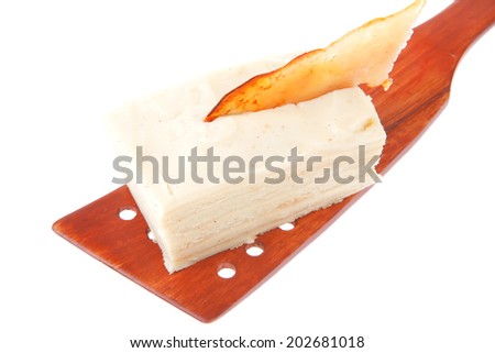 small cream mille-feuille cake schnitt  on wooden spatula over white