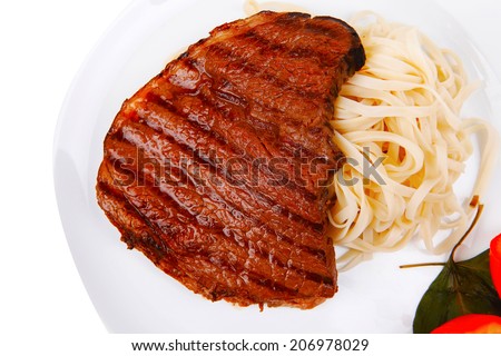 italian food : pasta with tomato on basil and roasted sirloin beef  steak on plate isolated over white background