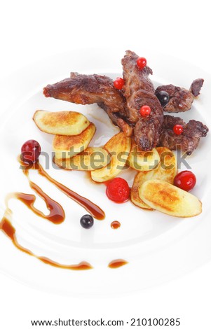 grilled beef meat with berries fried potatoes and cherry under sweet honey sauce on white plate isolated over white background