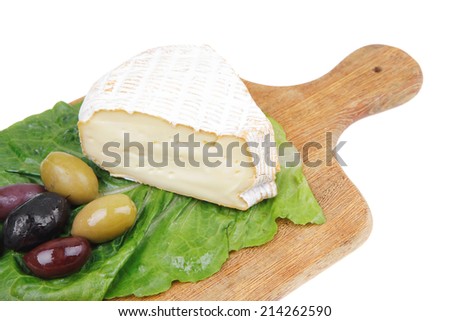 brie cheese on wooden platter with olives and tomato isolated over white background