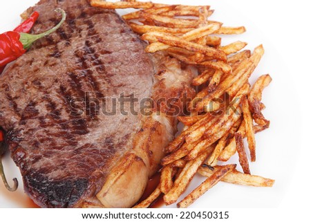 meat food : grill beef steak with potato chips and dry red hot chili peppers  on white round plate isolated on white background