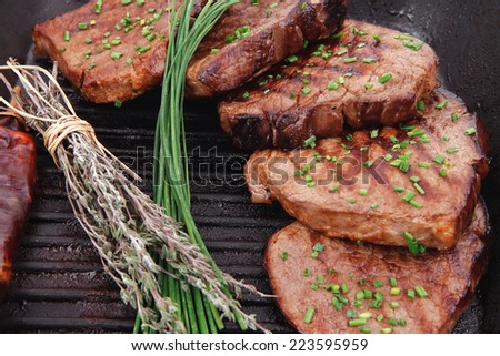 roasted beef meat on bbq pan with pepper and thyme isolated on white background