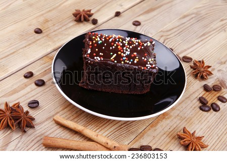 sweet dessert : black coffee and chocolate cake with cinnamon , coffee beans, and anise star on wooden table