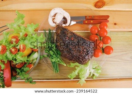 hot beef on transparent plate with salad bowl
