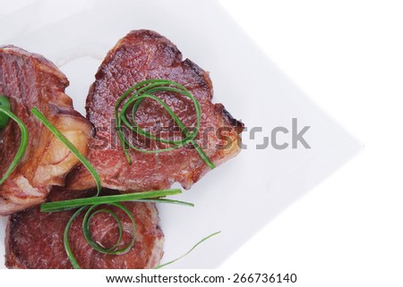 roasted beef meat strips steak on white ceramic plate isolated over white background