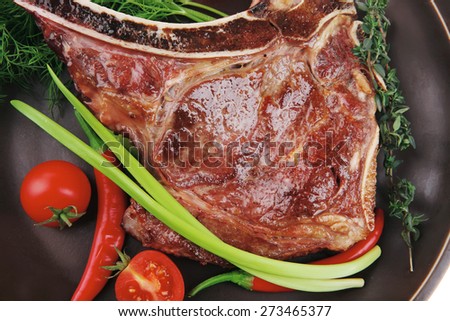 savory : grilled spare rib on dark dish with thyme pepper and tomato isolated over white background