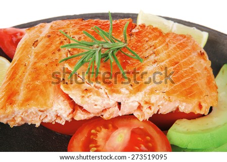 healthy diet food: hot sea grilled  red salmon fish fillet with lemon avocado and tomatoes on metal pan over wooden plate isolated on white background