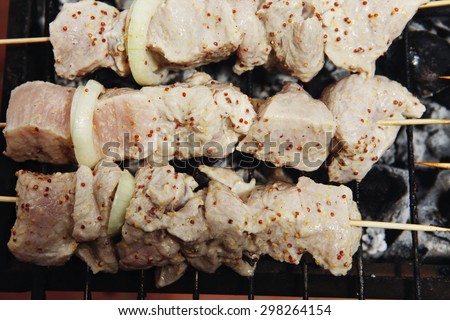 raw chicken breast shish kebab meat coated with sauce of dijon mustard prepared on grill over charcoal