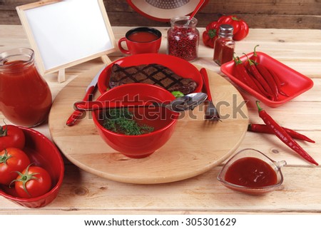 red lunch fresh grilled bbq roast beef steak plate green tomato soup ketchup sauce jug glass ground pepper american peppercorn modern cutlery served wooden plate table empty nameplate menu board