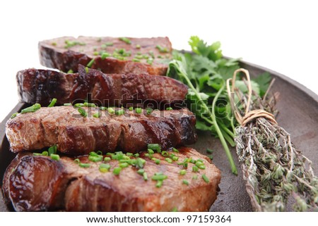 fresh grilled red meat with thyme on metal pan isolated on white background
