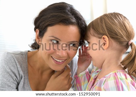 A little girl telling her mother a secret, indoor