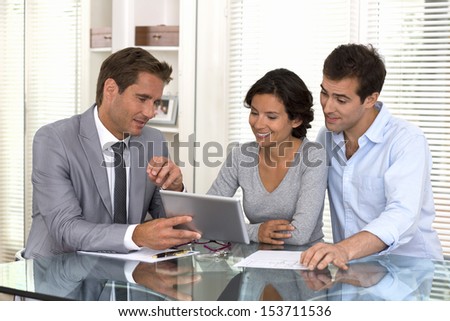Financial consultant presenting a new project investment to a smiling young couple