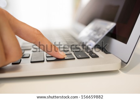 Close-up woman\'s hands with a credit card and using computer keyboard for online shopping