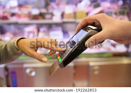 Woman hand with credit card swipe through terminal for sale, in market. code keyboard