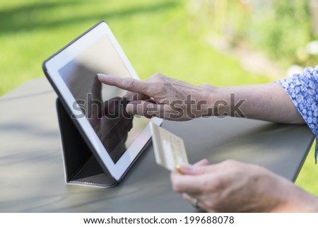 Woman senior using credit card and computer to shop on-line