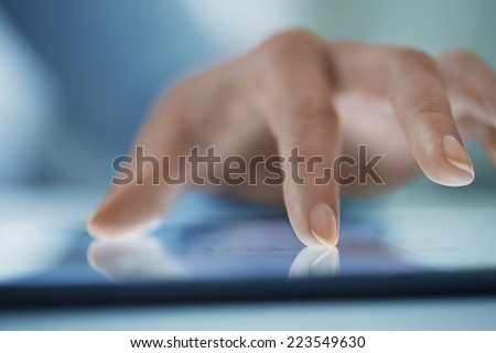 Woman using tablet pc, close-up on fingers