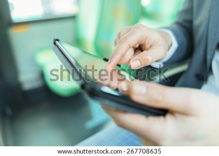 On bus man using digital tablet. Reading emails. texting message. Close-up hands