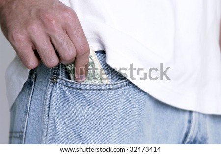 Man putting money in jeans pocket
