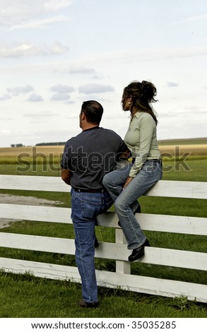 country couple against fence
