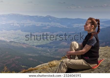 Hiker sitting on top of the mountain and looks into the distance.Freedom concept. Autumn mountain travel.