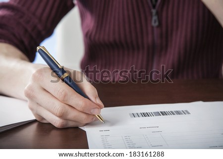Close-up of man paying bills pen in hand