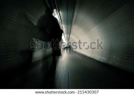 Couple crossing a dark tunnel. Image with blur zoom effect